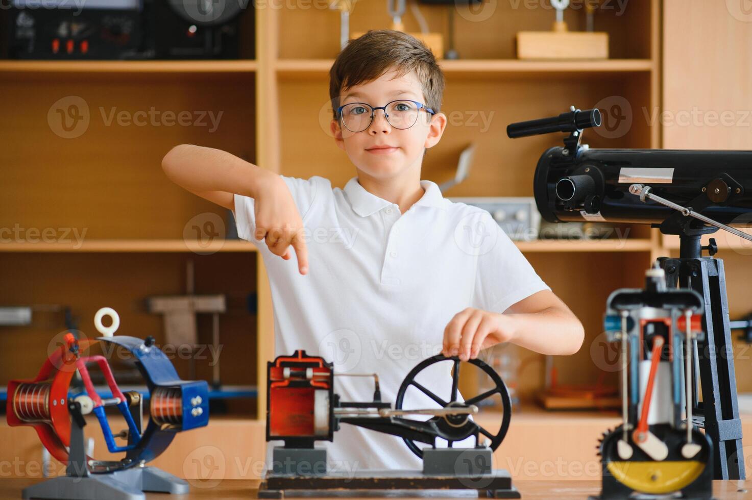 Physics lesson. A student at a desk with scientific instruments and a telescope photo