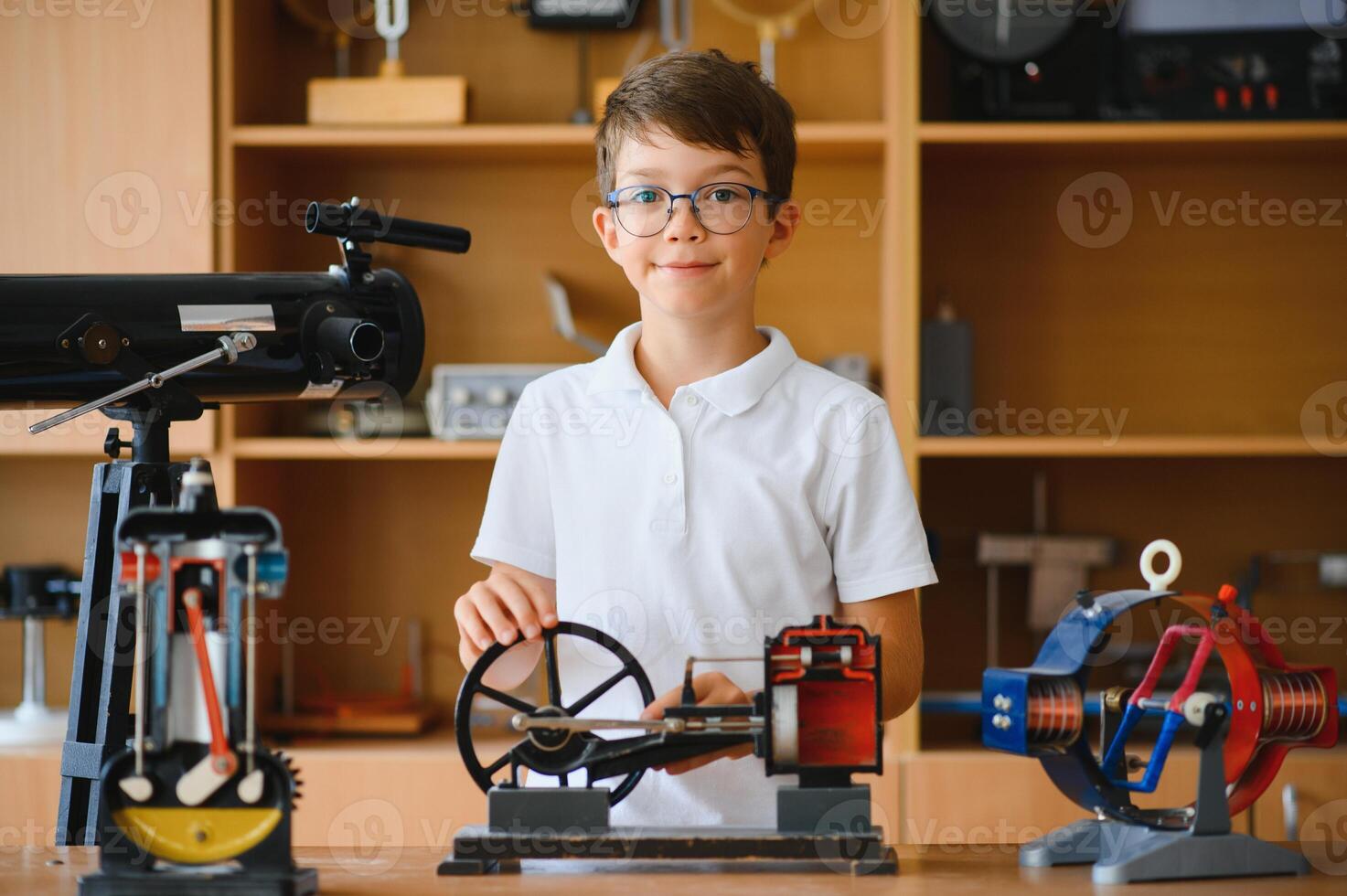 Physics lesson. A student at a desk with scientific instruments and a telescope photo
