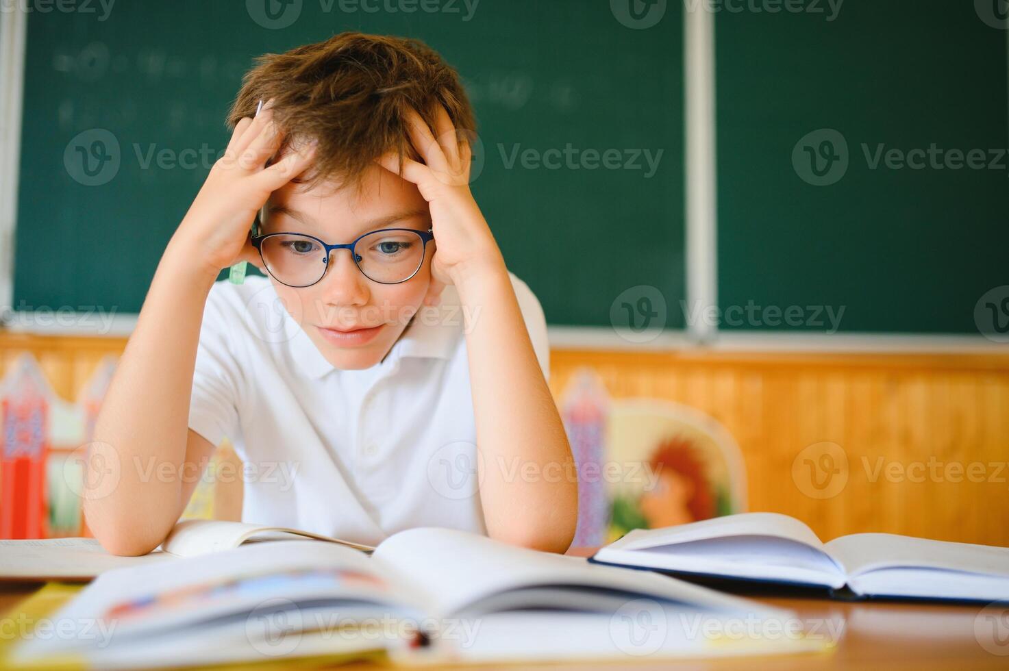 Portrait of little boy studying in classroom at school photo