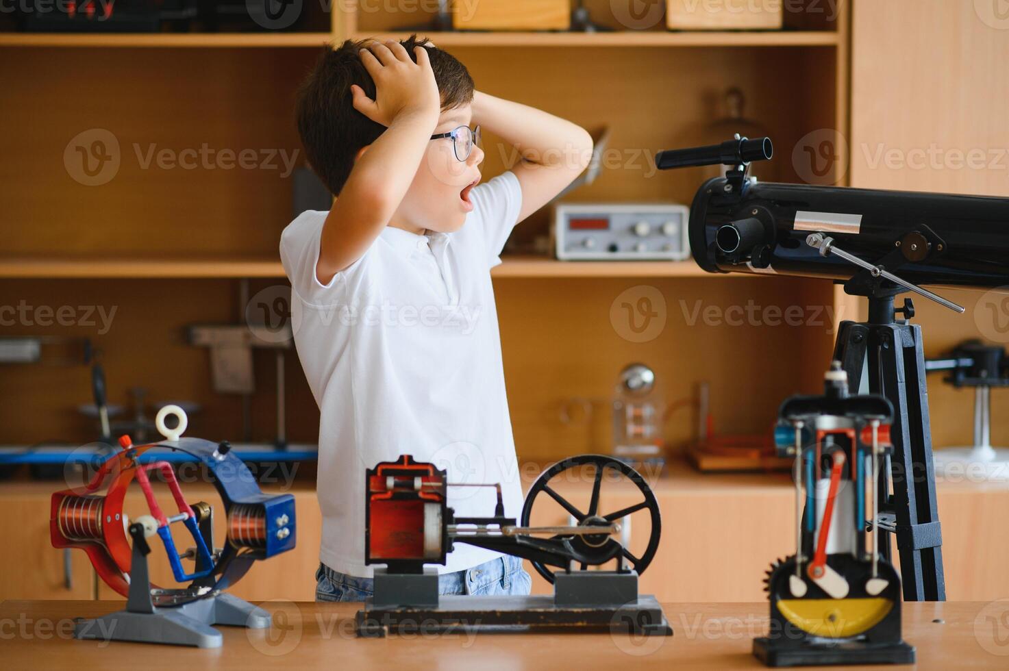 Physics lesson. A student at a desk with scientific instruments and a telescope photo