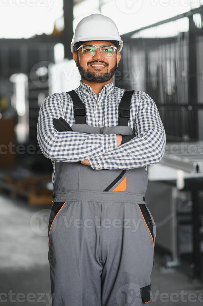 Portrait Indian male staff worker engineer supervisor in safety suit work in factory warehouse photo