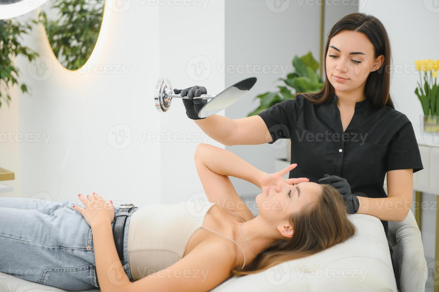 A woman looks in the mirror after an eyebrow tattoo session photo