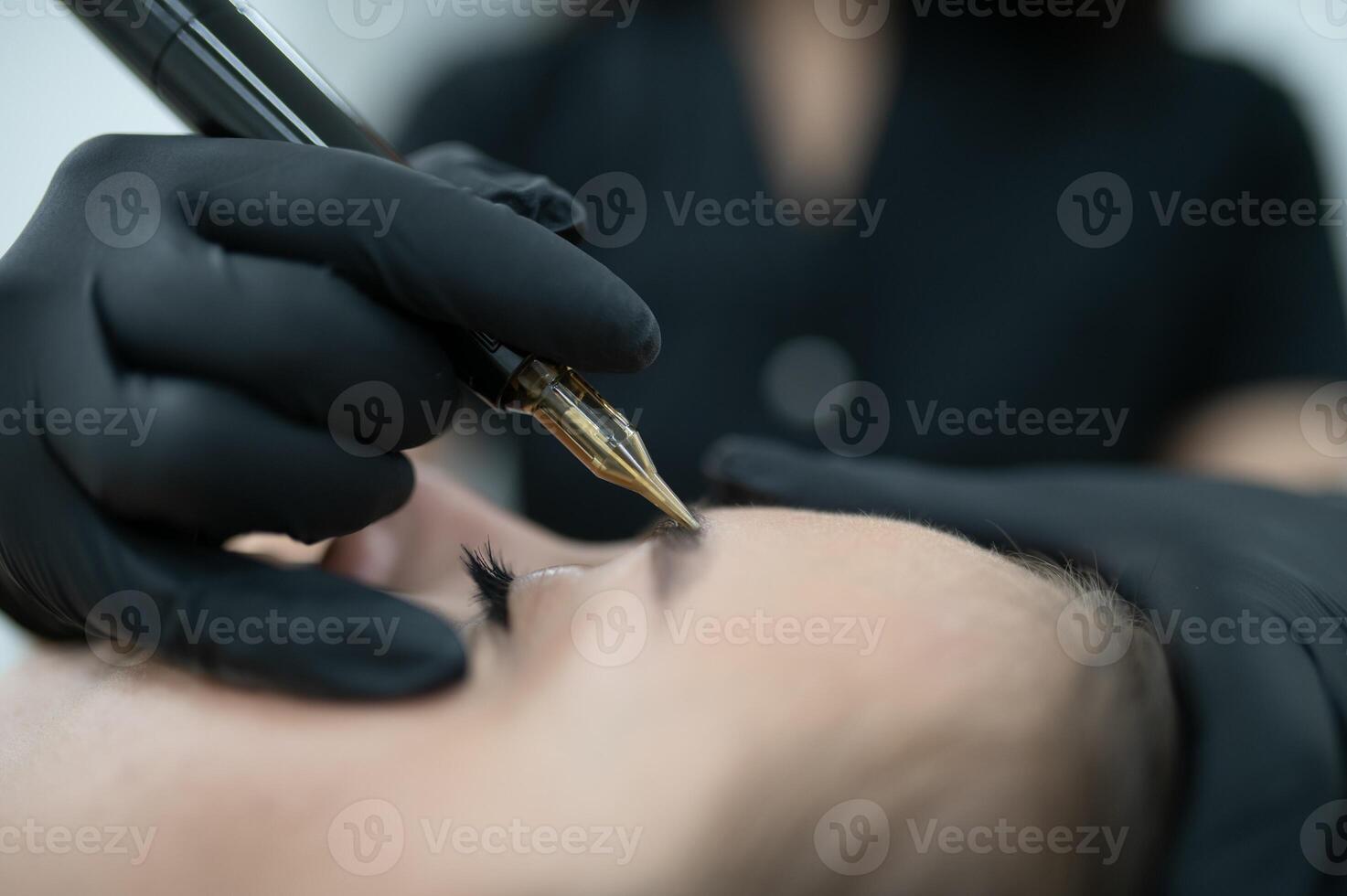 hands of the master who performs the procedure of permanent makeup of eyebrows. Permanent eyebrow makeup PMU for brunettes photo
