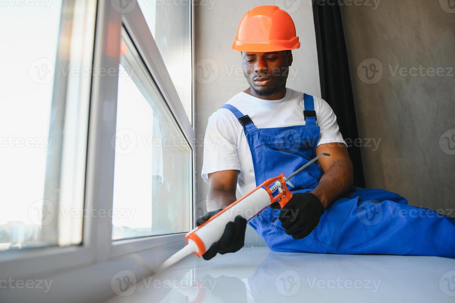 Worker in installing white plastic upvc window on house photo