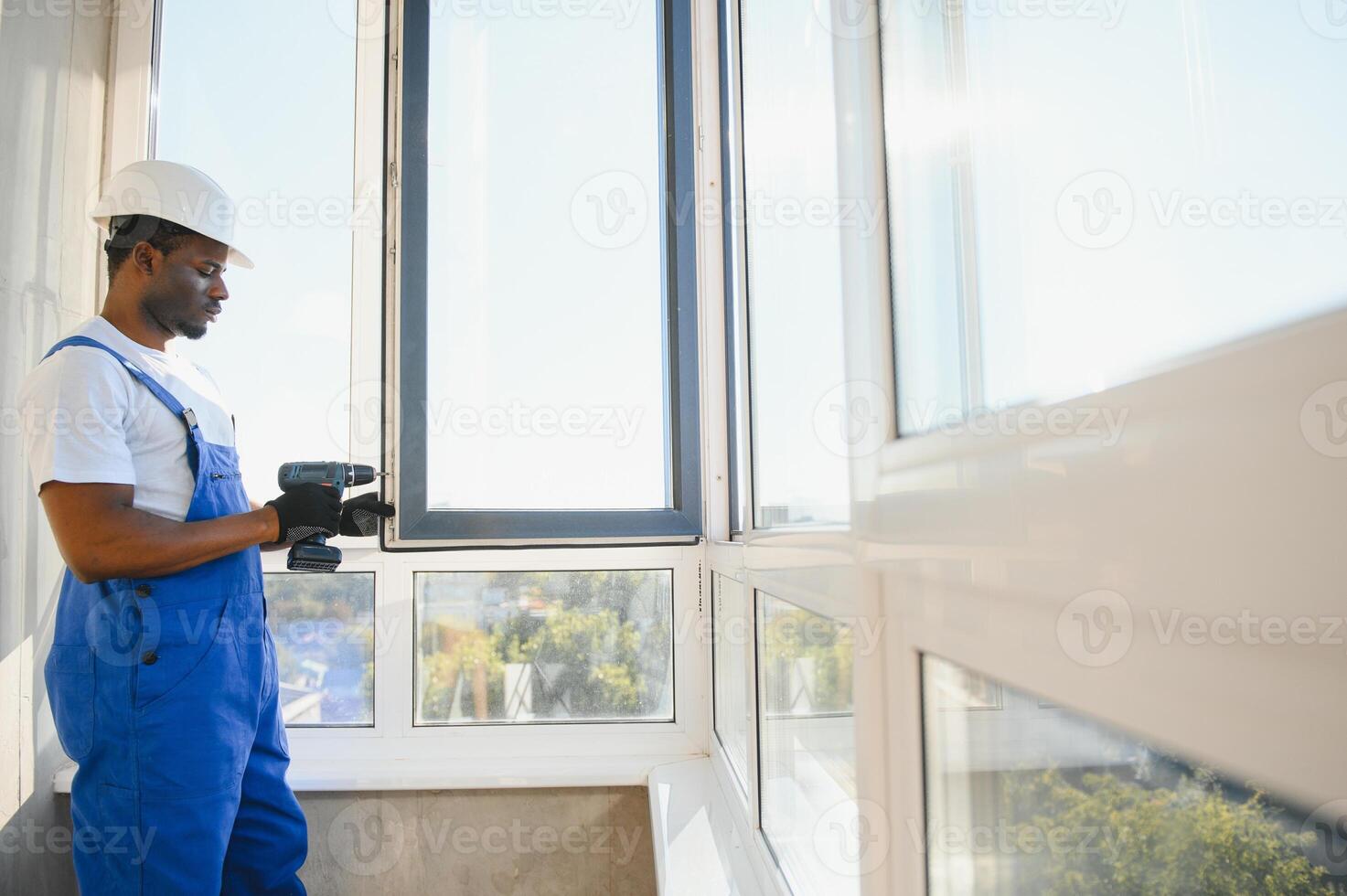 handsome young man installing bay window in new house construction site photo