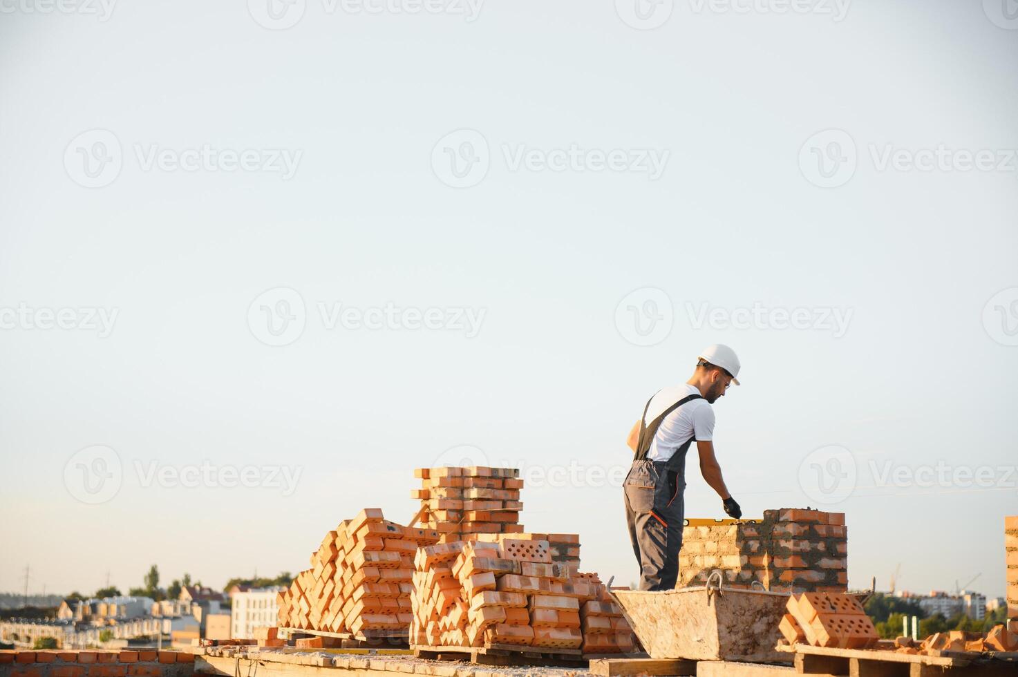 Construction worker in uniform and safety equipment have job on building photo