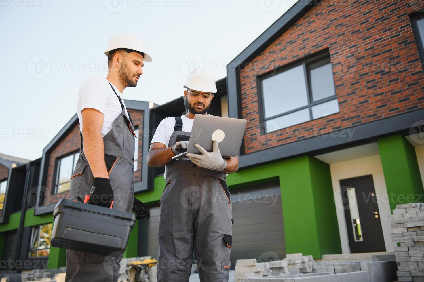 Building inspector and builder inspecting new cottage complex photo