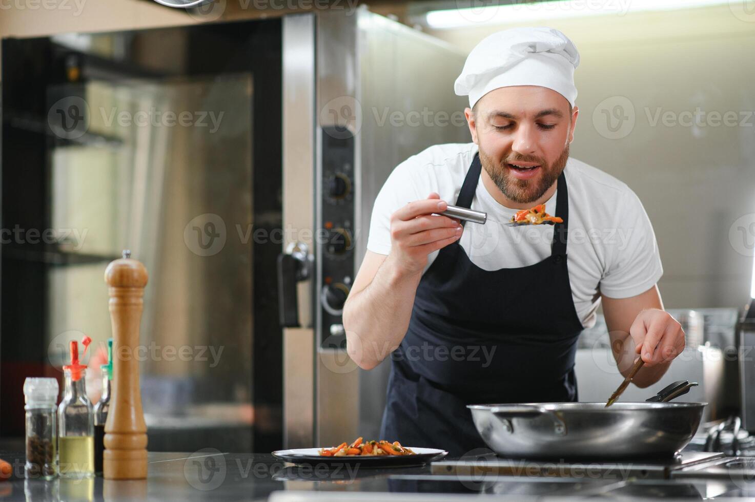 Chef cook in uniform cooking in the big cooker at the restaurant kitchen photo