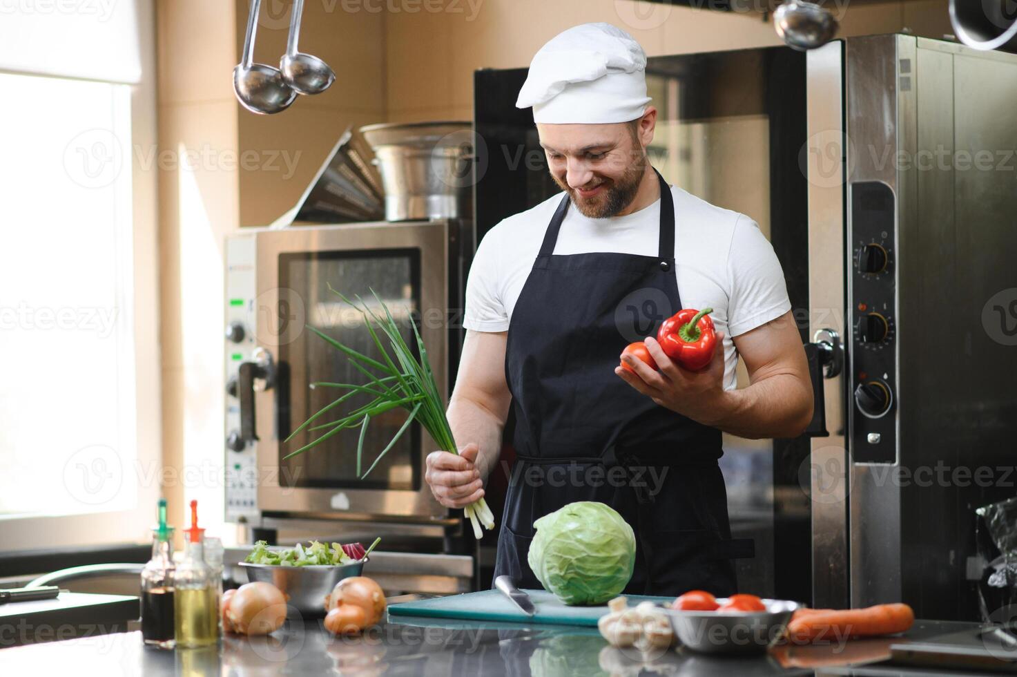 Chef cook in uniform cooking in the big cooker at the restaurant kitchen photo