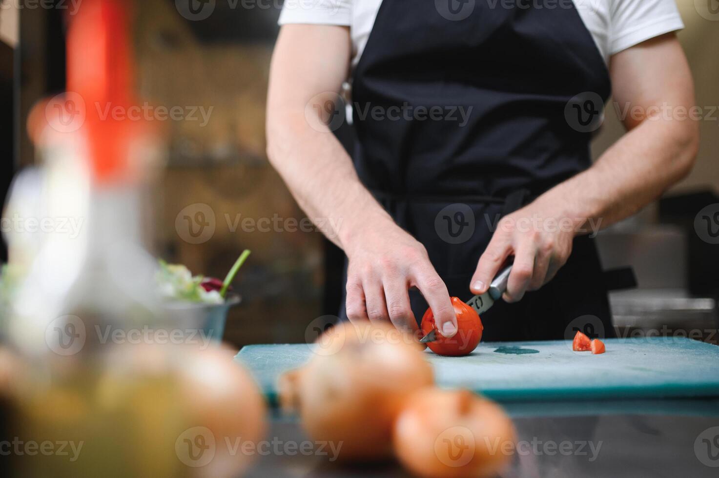 Chef cook preparing vegetables in his kitchen photo