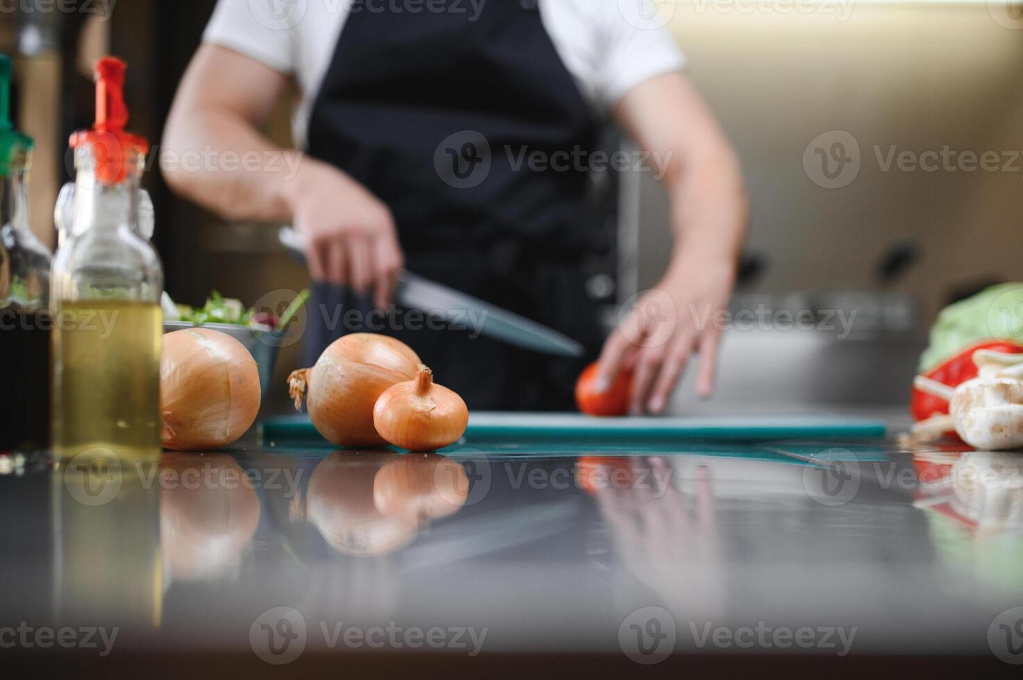 Chef cook preparing vegetables in his kitchen photo