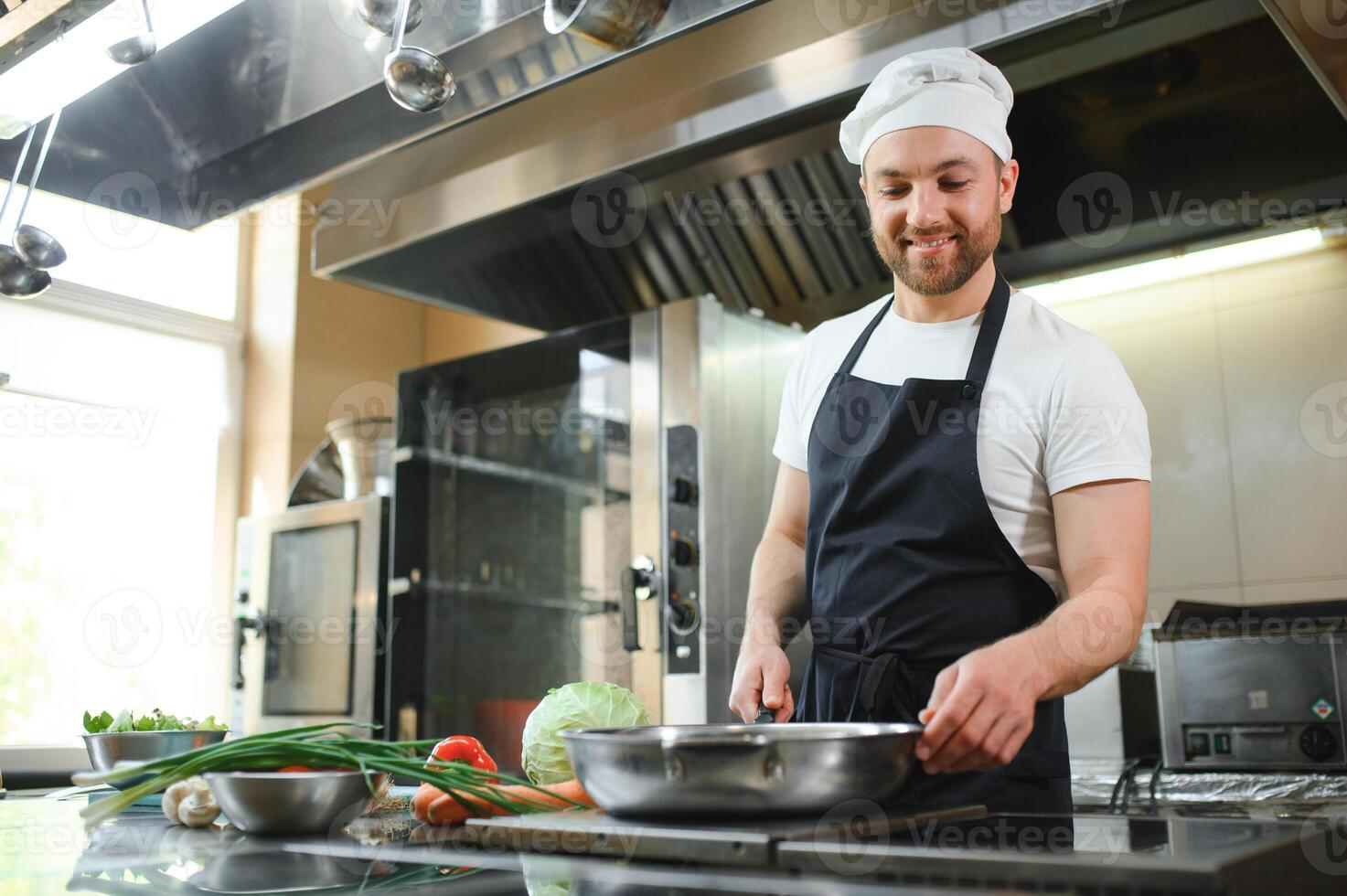 Chef cook in uniform cooking in the big cooker at the restaurant kitchen photo