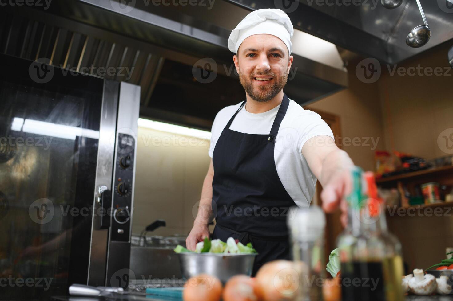 Portrait of happy caucasian male chef standing in restaurant kitchen, copy space photo