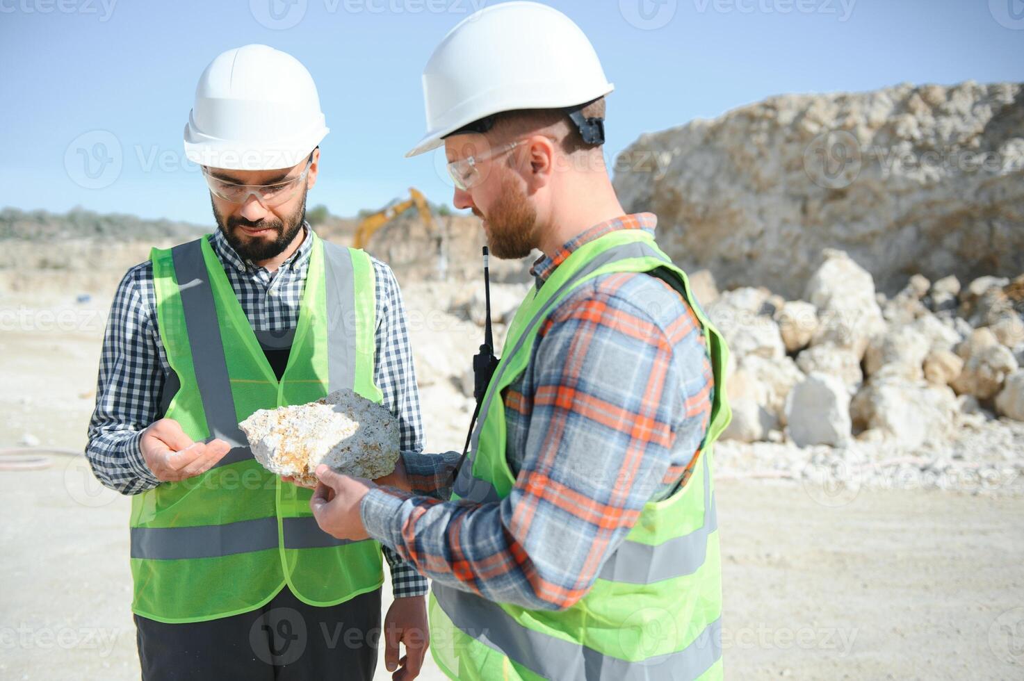 Two workers and quarry in background photo