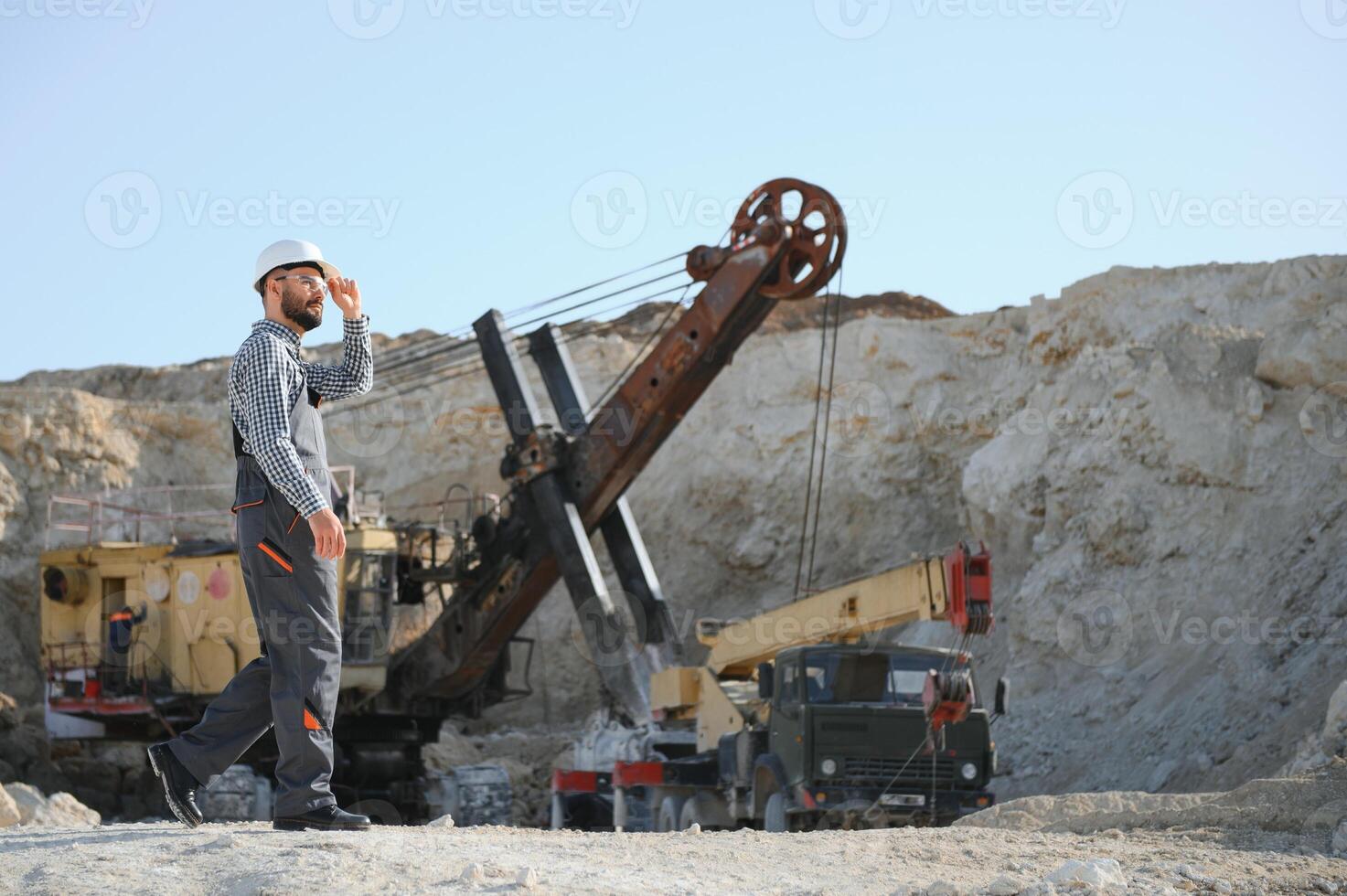 Male worker with bulldozer in sand quarry photo