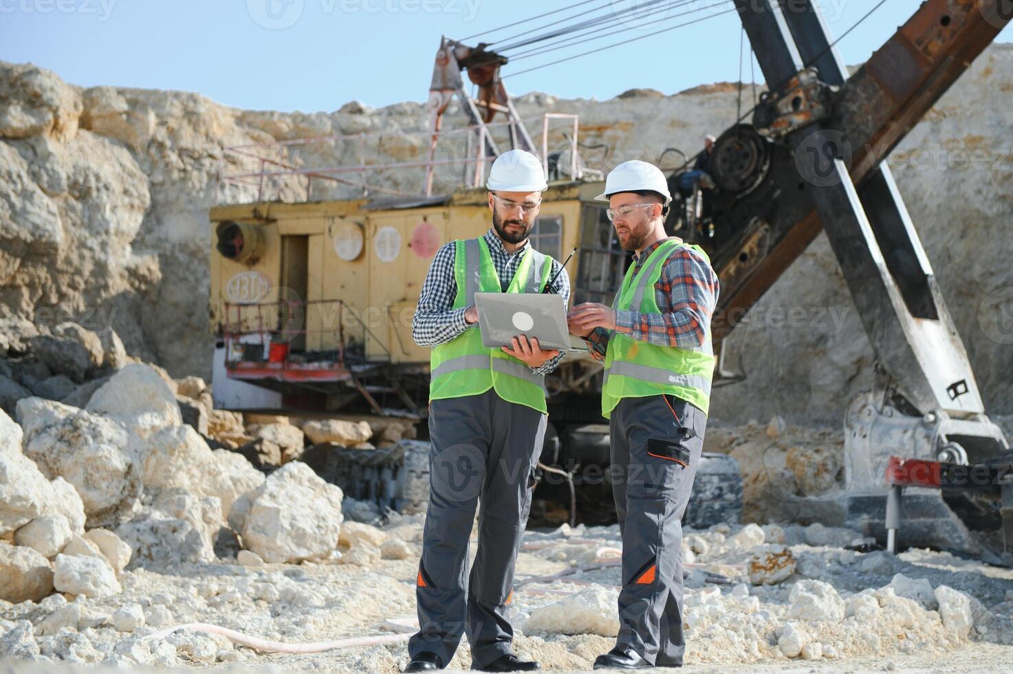 Two workers and quarry in background photo