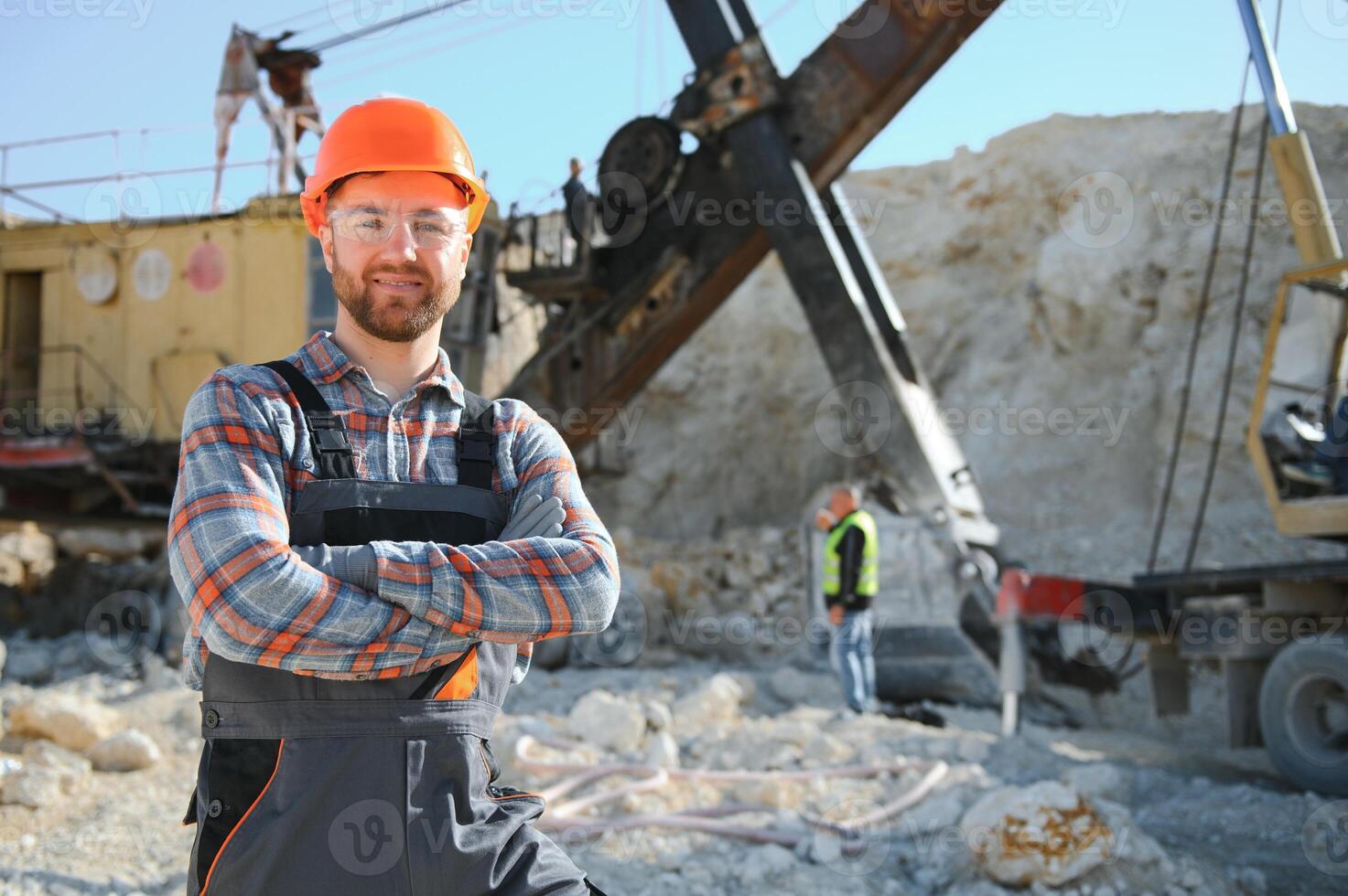 Worker in hardhat standing in stone quarry photo