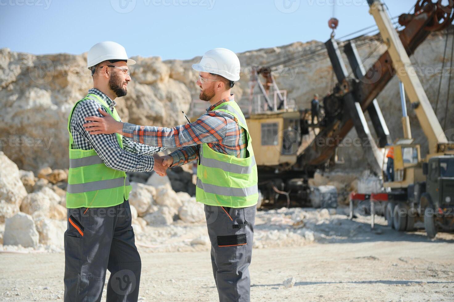 Two workers and quarry in background photo