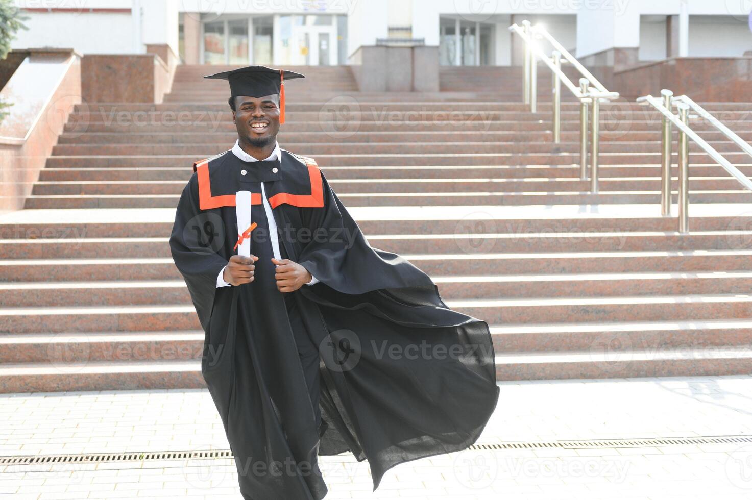 Happy graduate. Happy African man in graduation gowns photo