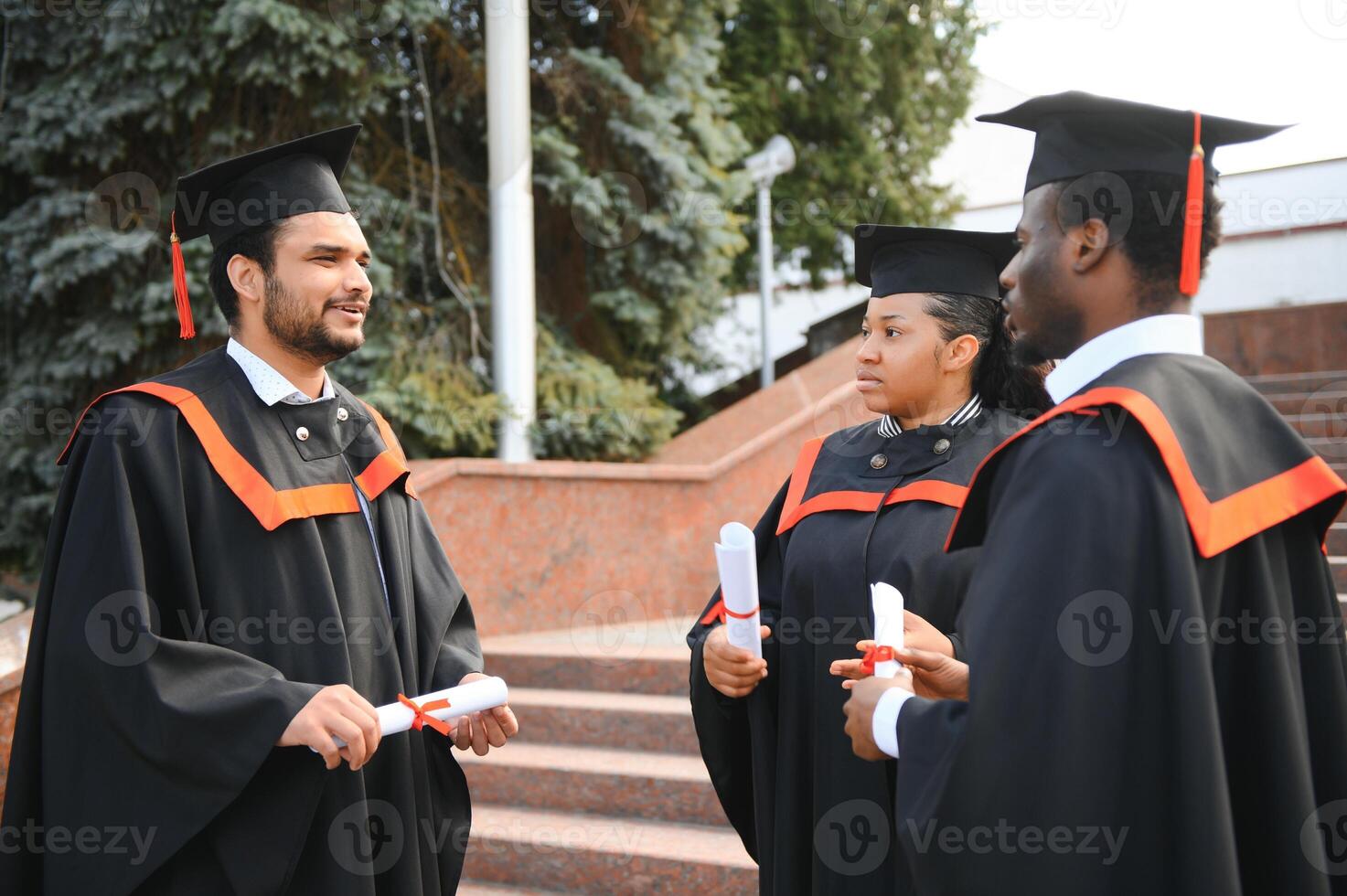 Diverse international students with diplomas at university campus photo