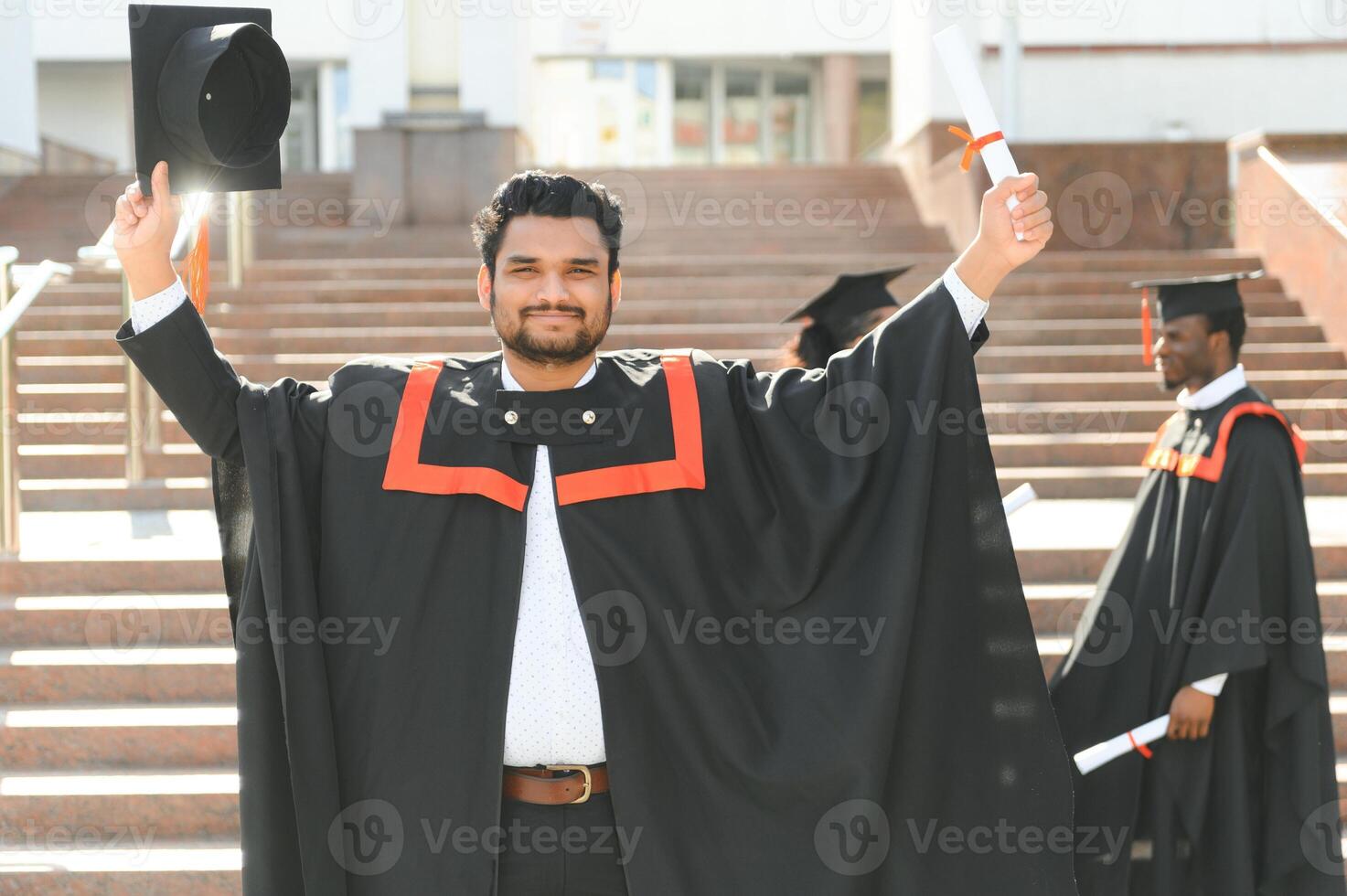 Handsome indian graduate in graduation glow with diploma photo