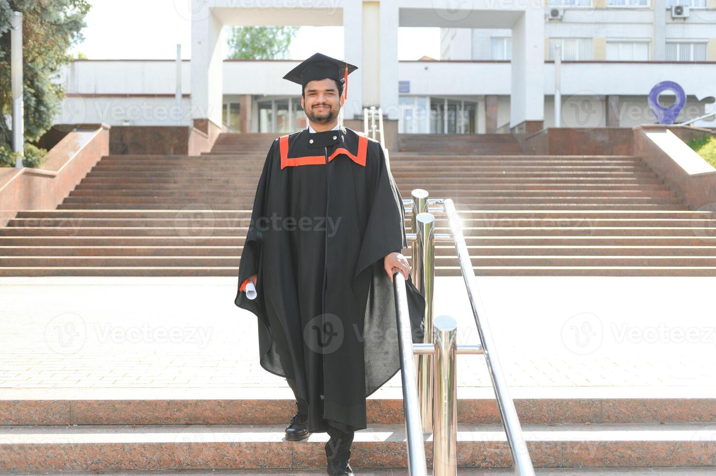Portrait of happy man, graduation or student in university campus photo