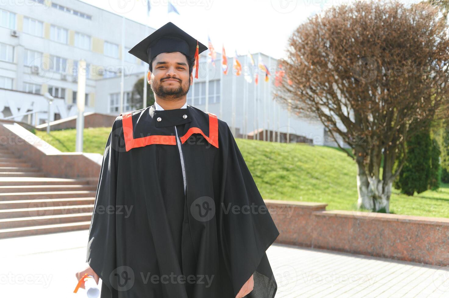 Portrait of happy man, graduation or student in university campus photo