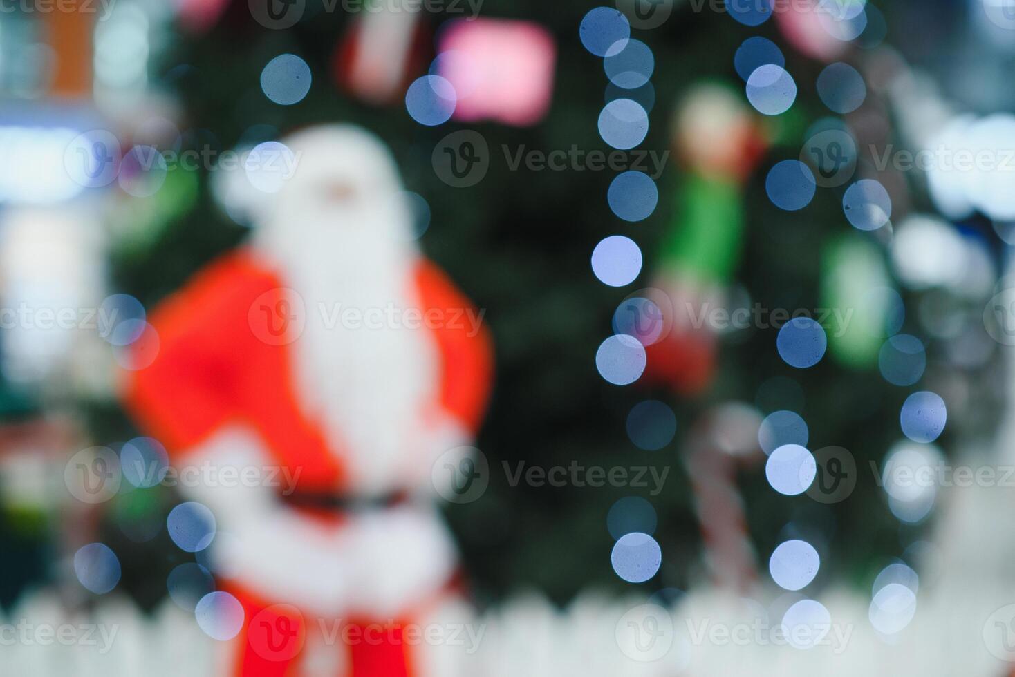 Blurred Santa Claus near the tree in the lobby of shopping center photo