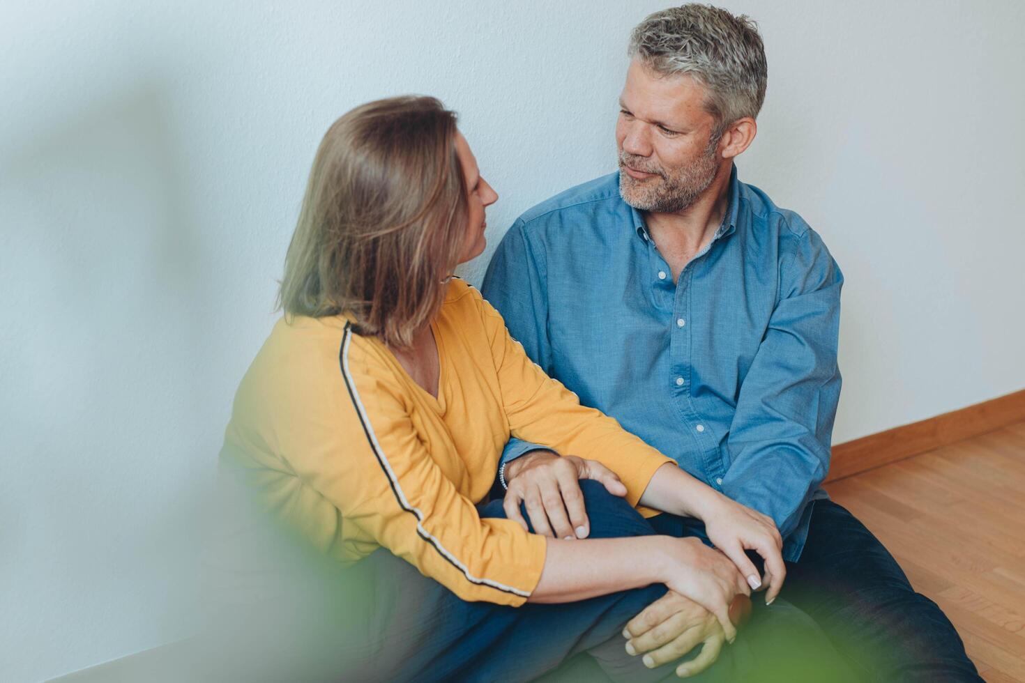 A happy couple relaxes on the floor, enjoying a playful moment in their home. photo