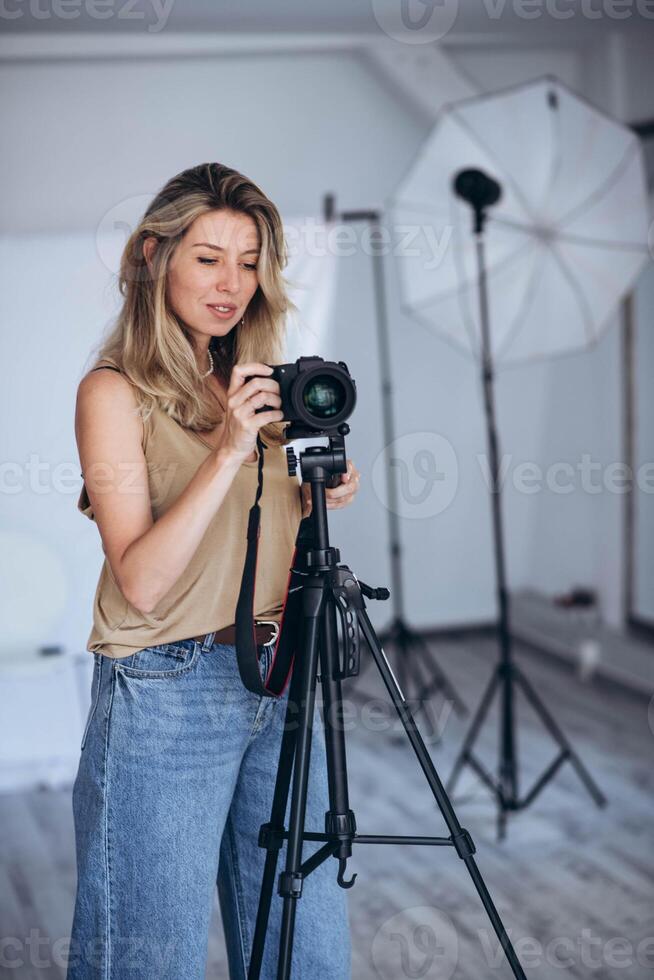 Woman photographer in a studio setting, using gear to capture creative images. photo