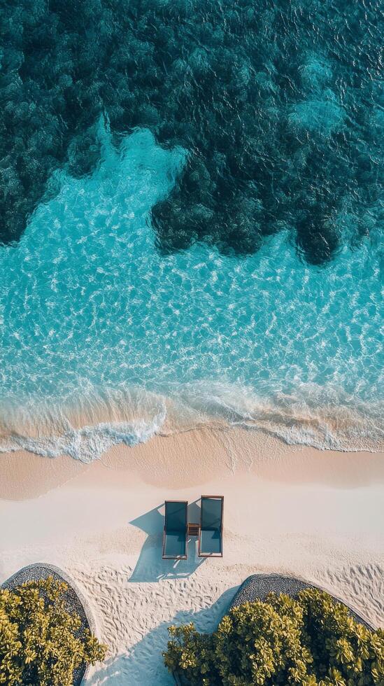 Relaxing sun loungers by the turquoise ocean on a sandy beach in a tropical paradise location photo