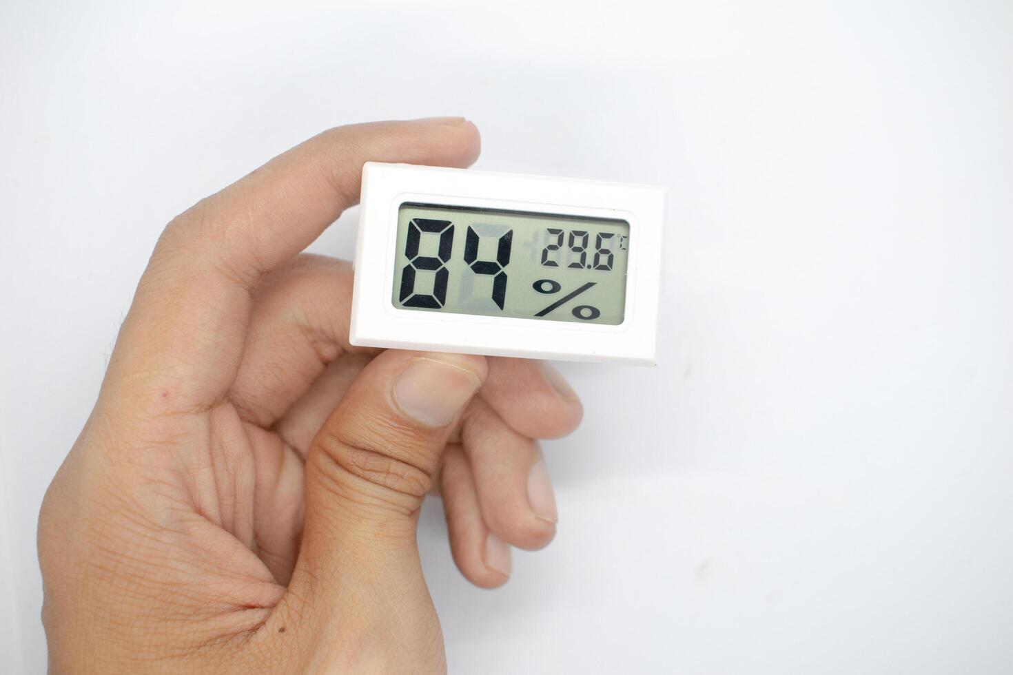 holding a humidity measuring thermometer, small size, portable, on a white background. photo