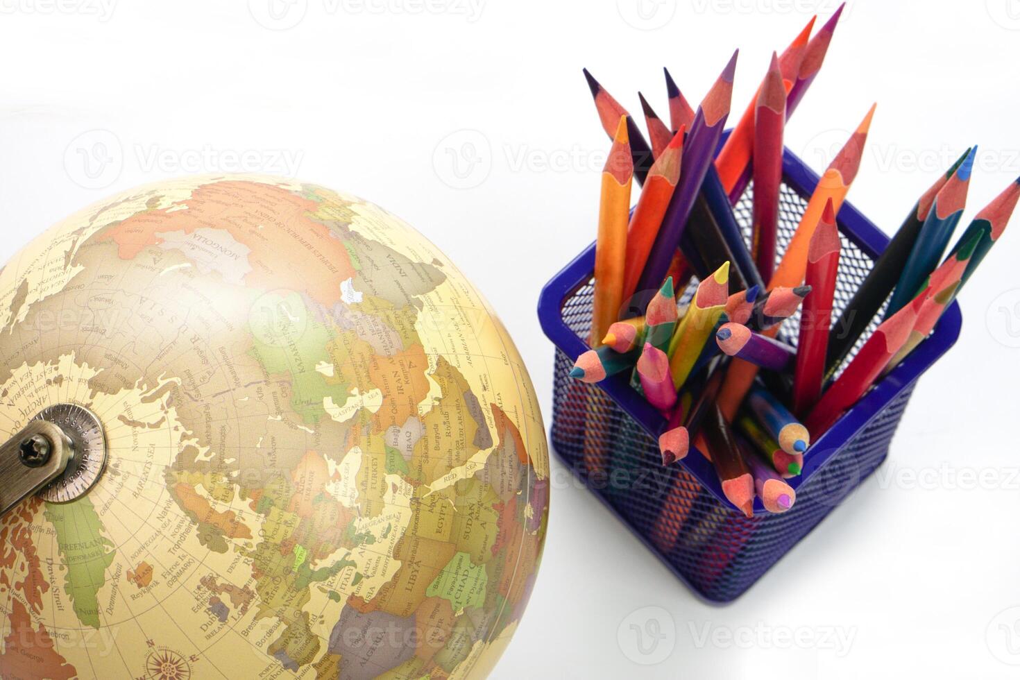 Selective focus, Top view globe with crayon or colored pencils in box on white background. Learning study and education concept. photo