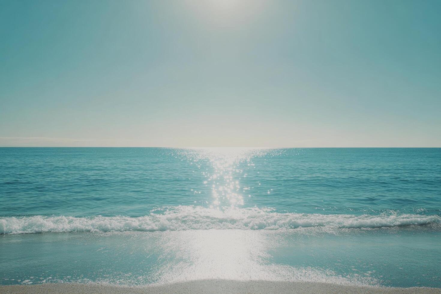 Tranquil ocean view with sparkling water and gentle waves under a bright sky at midday photo