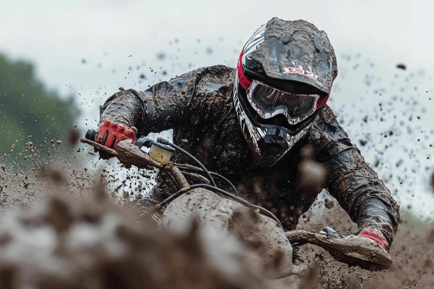Motocross rider navigating a muddy track during an overcast day in an off road competition photo