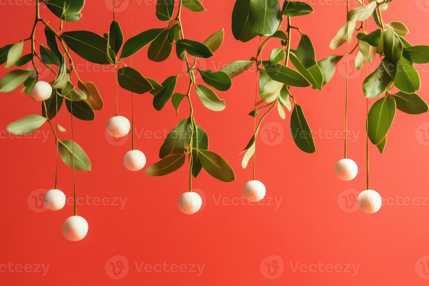 White Balls Hanging from Green Leaves Against a Red Background photo