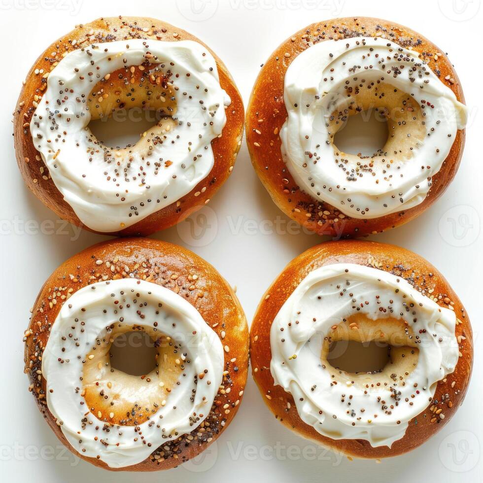 A collection of glazed and sesame seed doughnuts, arranged in a grid pattern on a white surface. photo