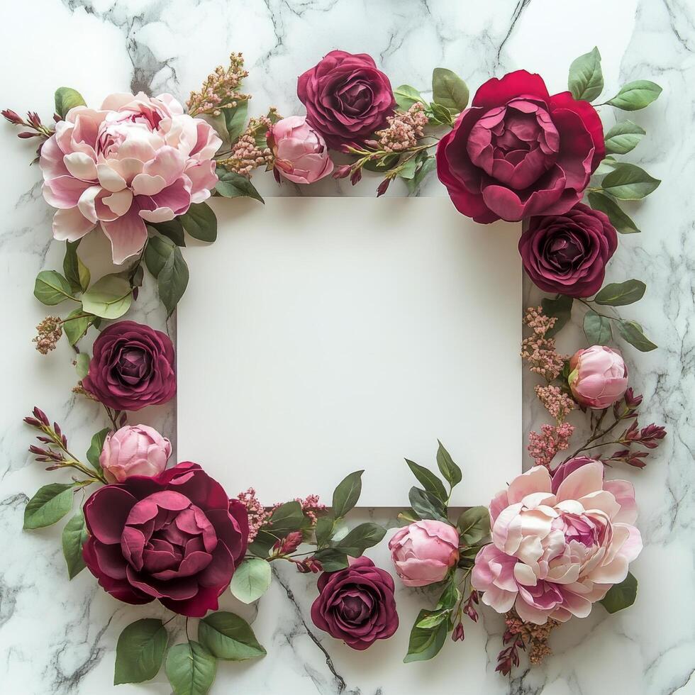 Decorative floral arrangement surrounding a blank frame on a marble tabletop photo