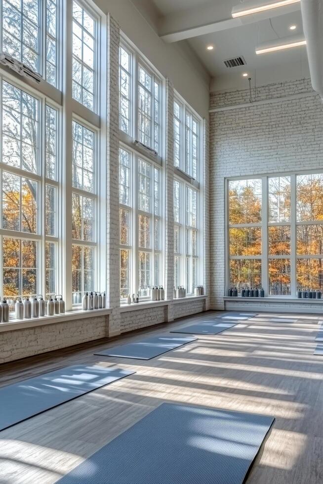 Bright and spacious wellness studio with large windows overlooking nature in the afternoon photo