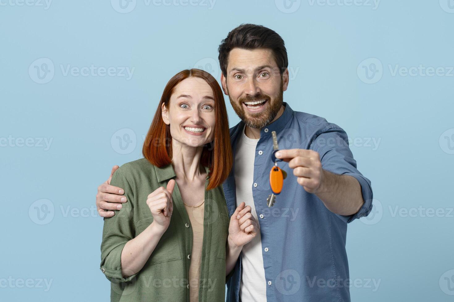 Happy couple holding keys to new home smiling at camera photo