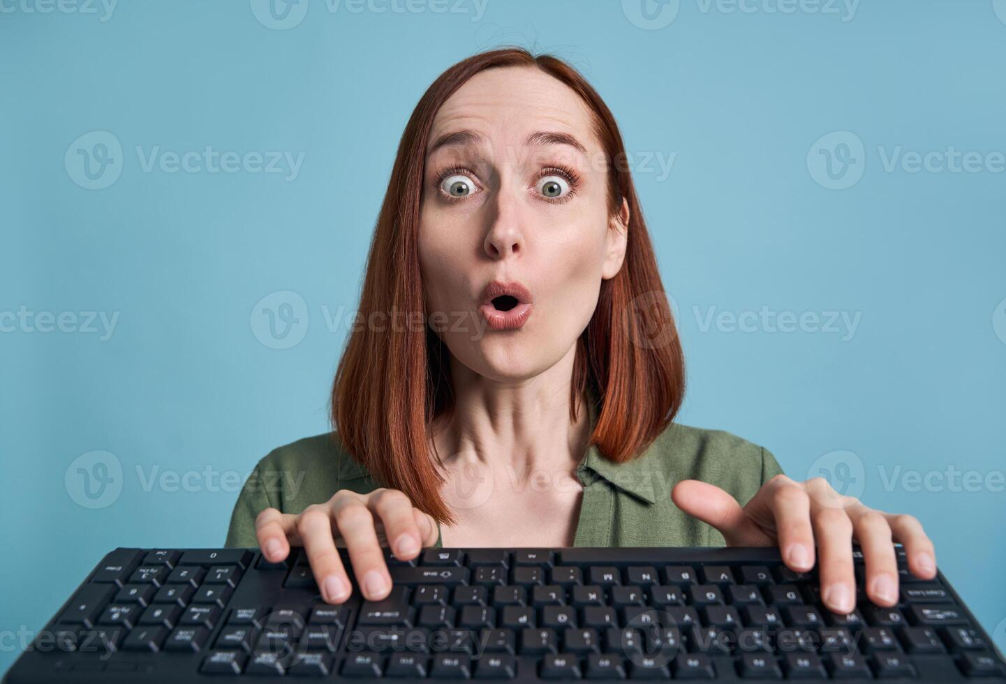 Shocked woman working on computer with blue background photo
