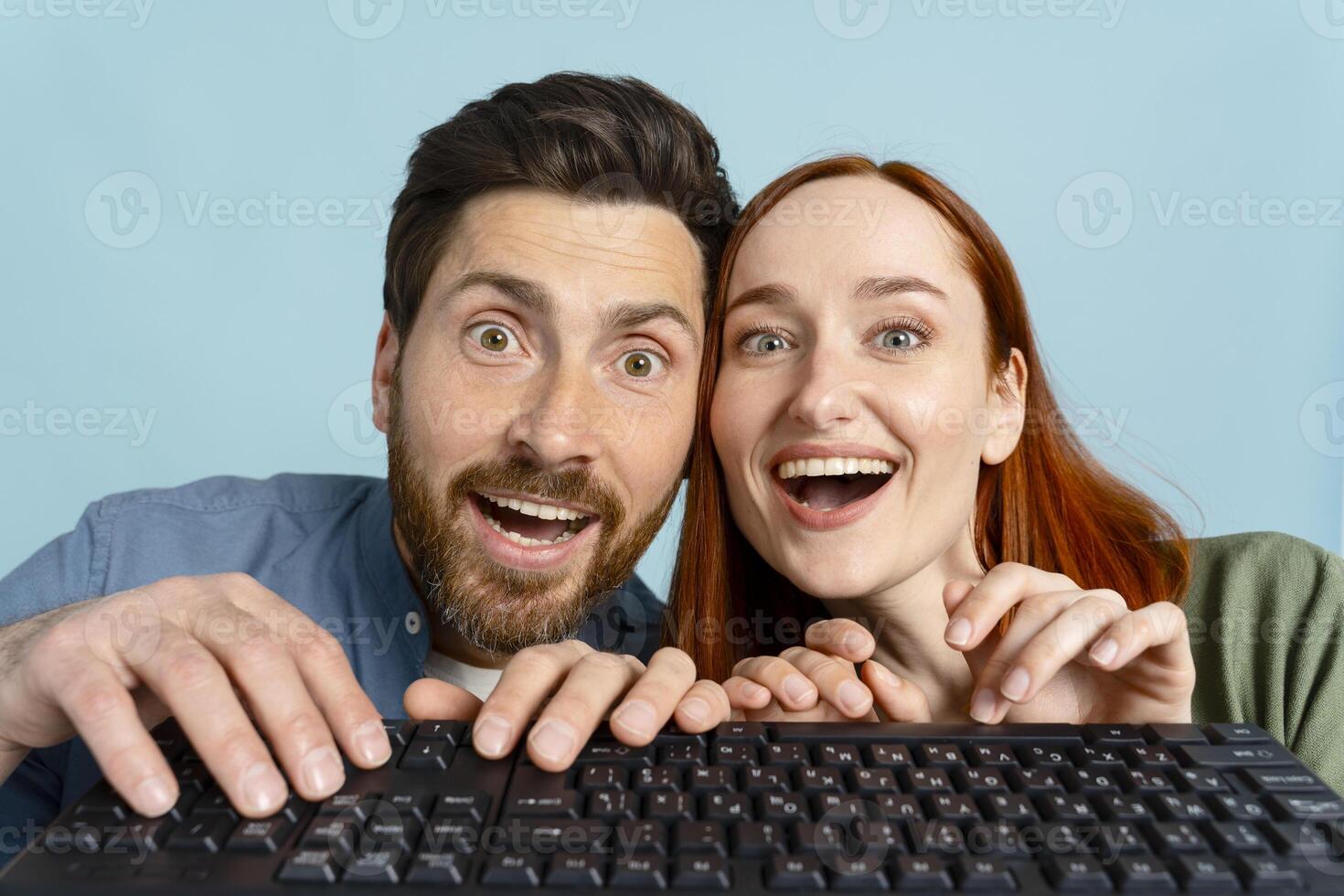 Young couple using computer is amazed by what they see on the screen photo