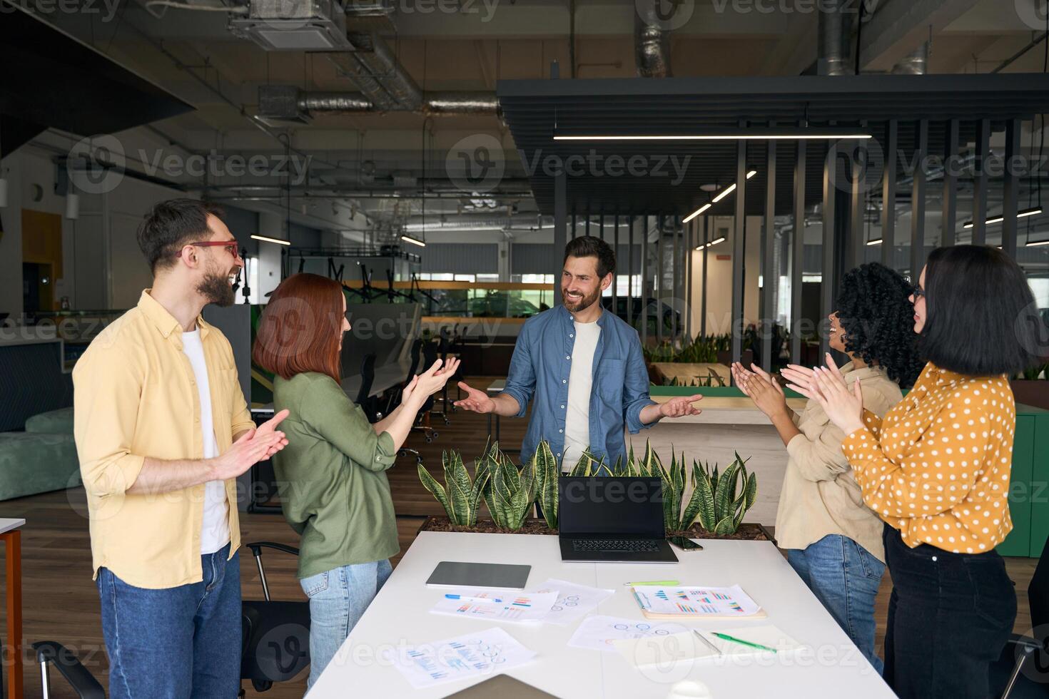 Diverse team applauding a colleague after a successful presentation photo