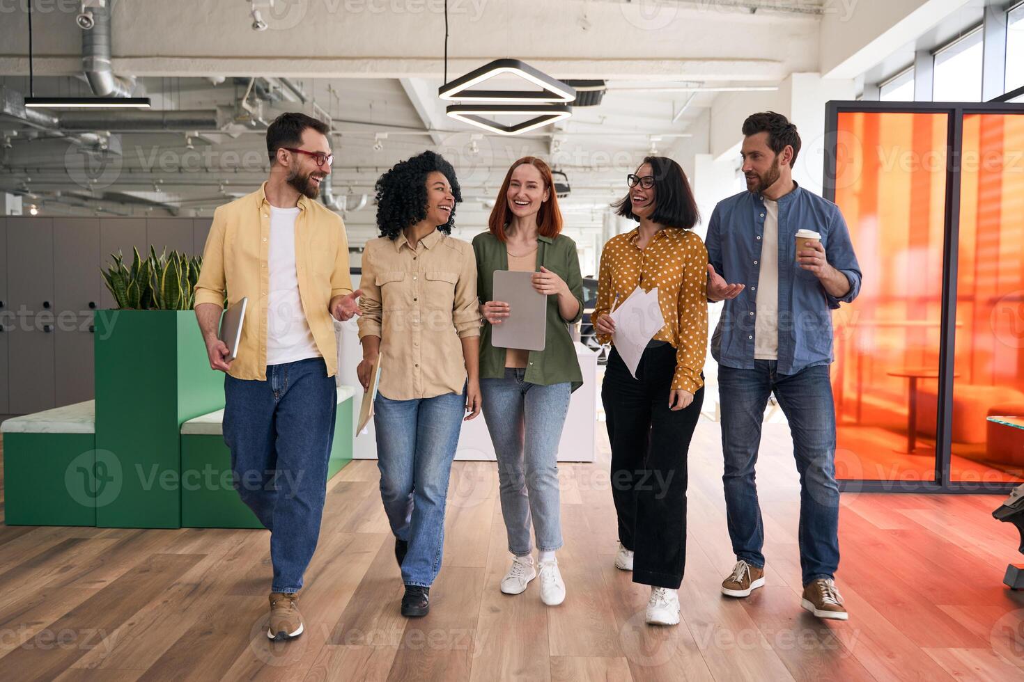 Diverse business team walking and talking in modern office photo