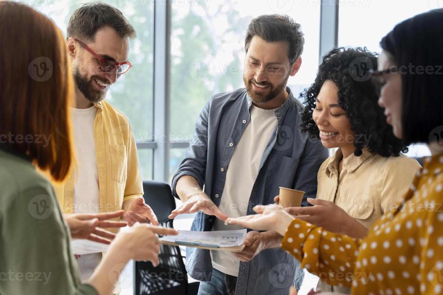 Diverse team of managers having meeting discussing documents in modern office photo