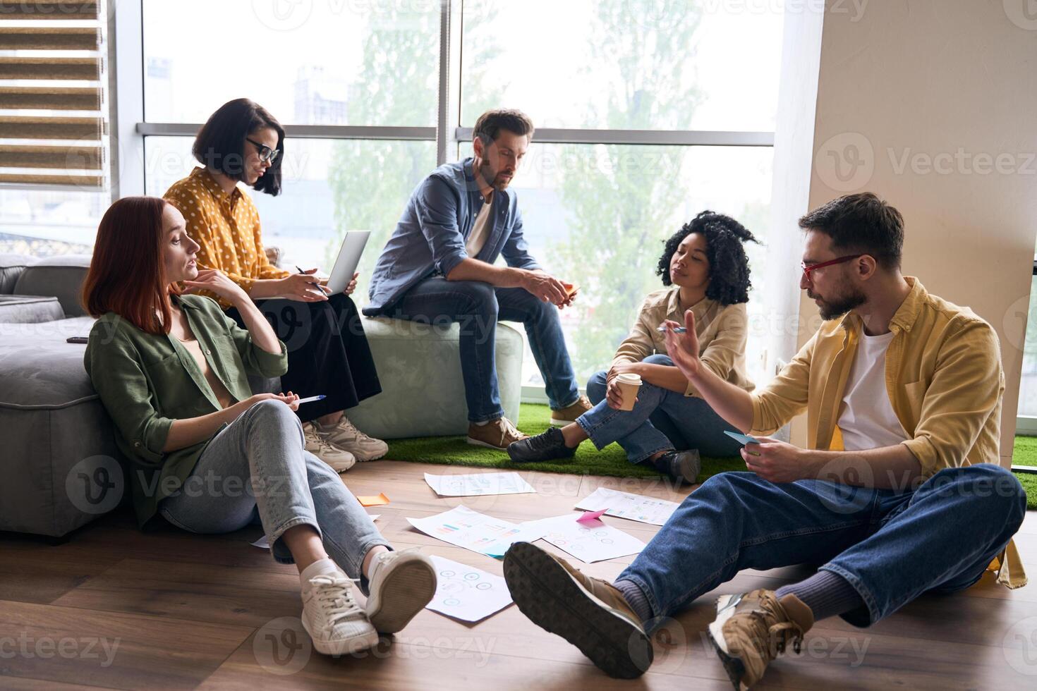 Group of young professionals having brainstorming session in modern office photo