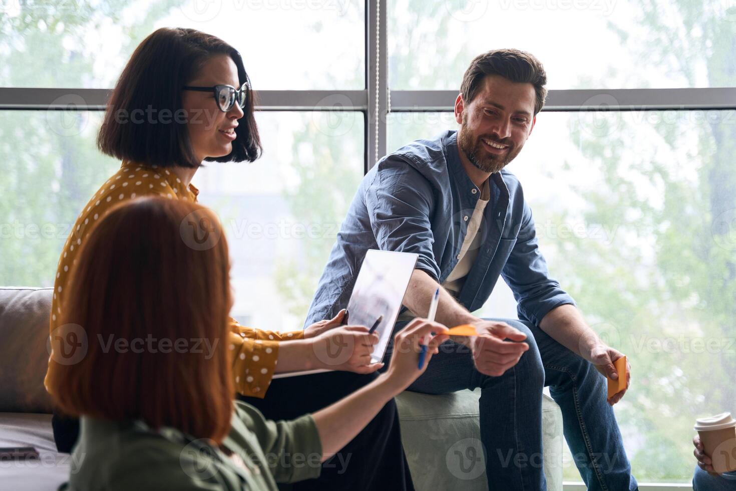 Creative team brainstorming using sticky notes during meeting photo