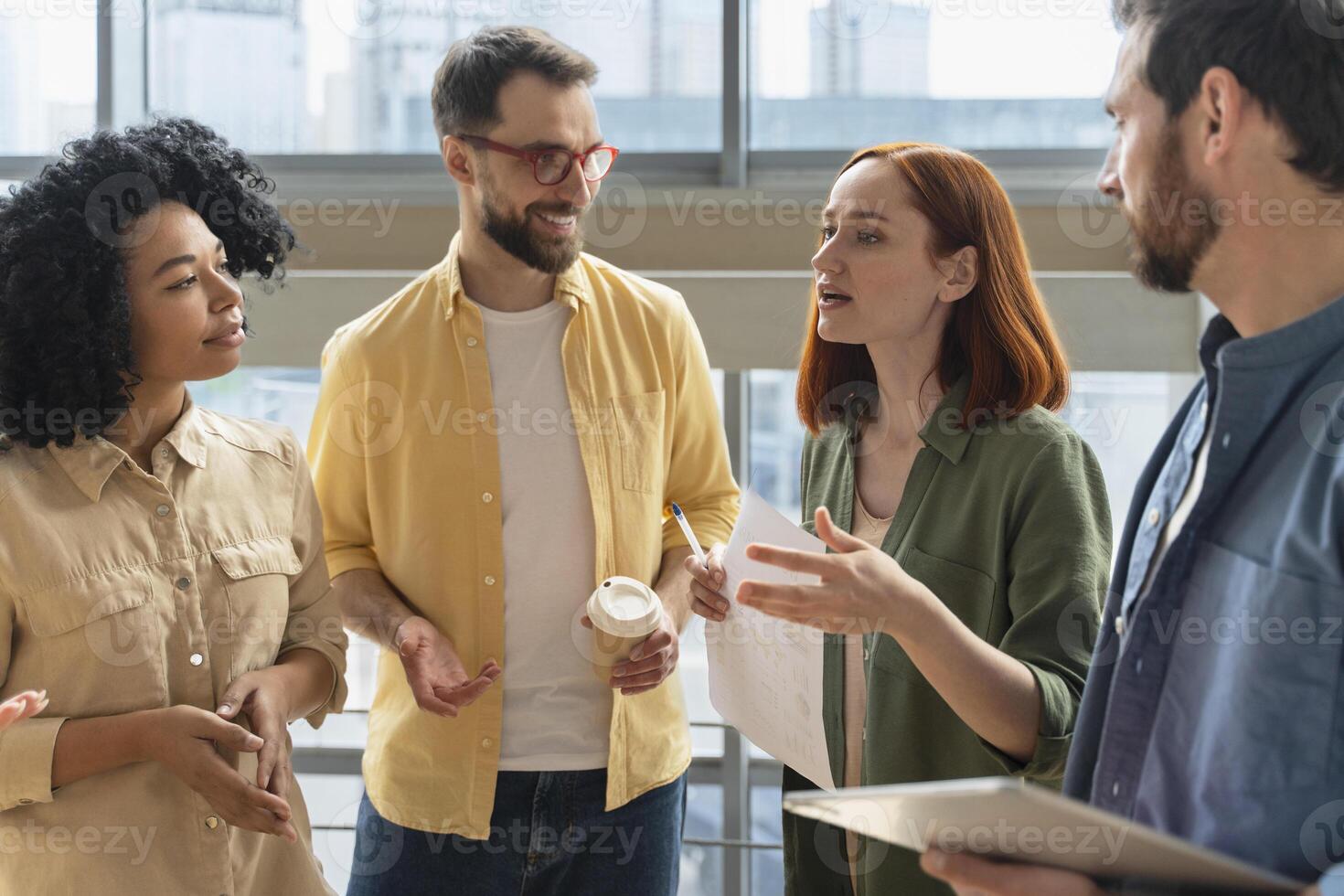 Group of diverse businesspeople having informal meeting discussing business issues in modern office photo