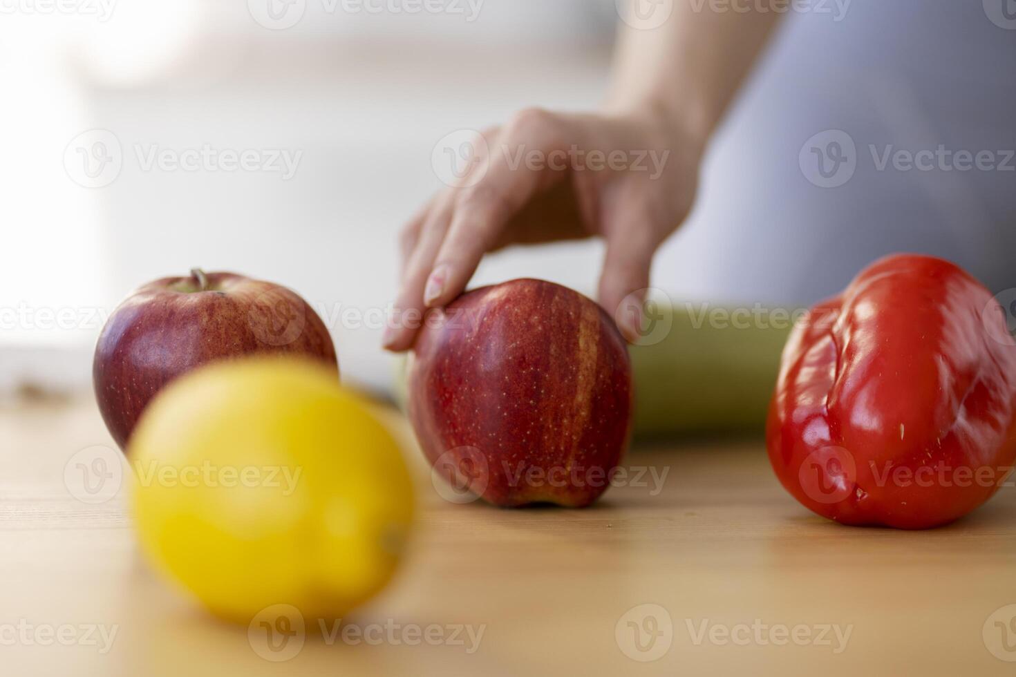 Woman choosing fresh red apple for healthy vegan meal photo