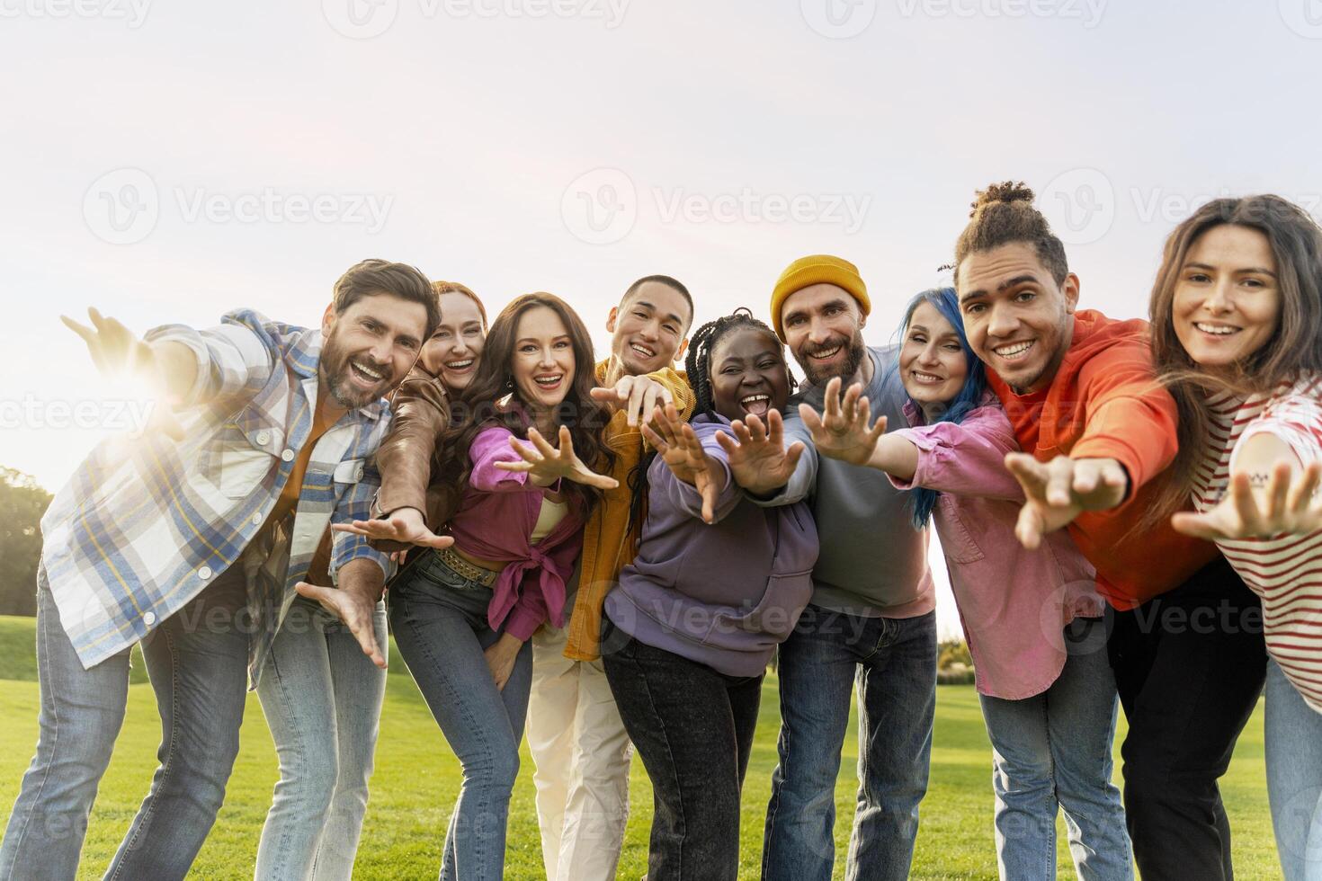 Group of diverse people reaching out with open arms photo